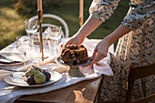 Bundt cake and pears on garden table with linen tablecloth