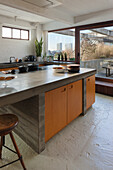 Kitchen island with concrete slab in renovated loft apartment