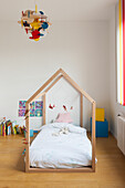 Child's bed under house-shaped frame