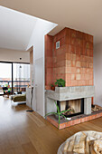 Fireplace made of terracotta tiles and concrete in open-plan living room