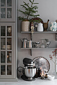 Crockery and Christmas decorations on shelves in kitchen with grey walls