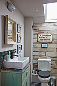 Vintage cupboard used as washstand, toilet and ceramic, wood-effect wall tiles in bathroom