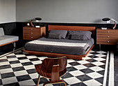 Mid-century modern furniture in masculine bedroom with chequered floor