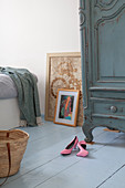 Pink court shoes on pale blue wooden floor in bedroom