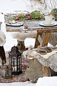 Gedeckter Tisch auf abgenutztem Teppich im winterlichen Garten