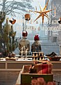 Furniture shop with Christmas decorations, children sitting in front of the shop window