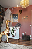 Giraffe figure and baby bed with canopy in the room