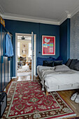 Double bed next to a door in bedroom with blue walls