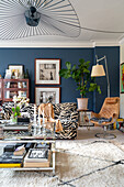 Sofa with Animal print upholstery and glass coffee table in the living room with blue wall