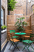 Seat on small terrace with privacy screen in an inner courtyard
