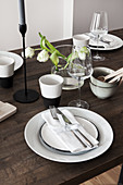 White place settings and tulips on wooden table