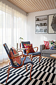Retro Sessel mit Kissen auf schwarz-weiß gestreiftem Teppich
