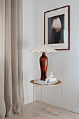 Side table with table lamp below picture in corner