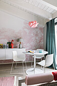 White table with chairs and wall mounted console table in front of pink wallpaper in the girl's room