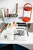 Stationery and book with sketch on desk