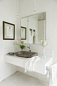 White washstand with rustic sink and vanity mirror in bathroom