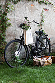 Bicycle with bag against the wall, picnic basket in front of it