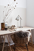 Desk and rattan chair with sheepskin rug
