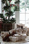 Geschmückter Baum und Weihnachtsgeschenke vor Fenstertür