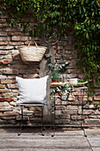 Sitzplatz mit mediterranem Blattgrün vor Backsteinmauer