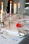 Table set in white with candles and pink roses