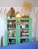 Antique glass-fronted cupboard painted green