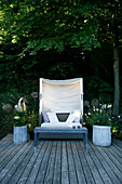Lounge sofa with canopy and planters on wooden deck