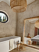 Large mirror and bathtub in the bathroom with neutral colored walls