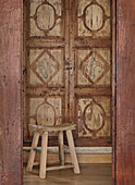 Wooden stool in front of a wooden door