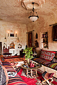 Wohnzimmer in einer türkischen Höhlenwohnung, eingerichtet mit türkischen Teppichen und Kissen