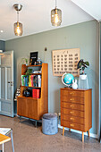 Retro bookcase and chest of drawers against light grey wall