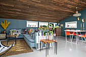 Sitz- und Essbereich in offenem Wohnraum mit rustikaler Holzdecke