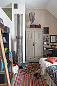 Vintage wood stove and wardrobe in the children's room with high ceilings