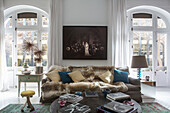 Französisches Sofa mit Felldecke und Kissen im Wohnzimmer mit zwei Balkonen