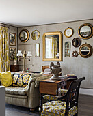 Collection of convex mirrors in muted room with tellow fabrics