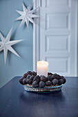 Candle with wreath of closed conifer cones
