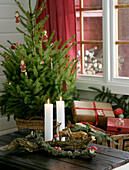 Christmas arrangement of branches, candles, animal figurines and small toadstools