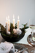 Schwarze Schale mit Adventsgesteck auf gedecktem Tisch