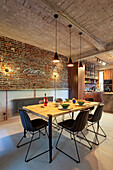 Dining area in front of brick wall in a loft