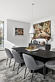 Black dining table with grey upholstered chairs