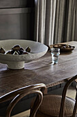 Paper mache bowl on dark wooden table in dining room