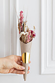 Posy of dried flowers in paper cone