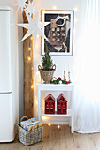 Weihnachtsdekoration in der Küche: Holzbalken mit Lichterkette und Papierstern und Teelichthalter-Häuschen