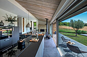 Elegant kitchen in open-plan interior with sliding glass door and terrace