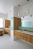 Zwei Waschtische mit hellen Holzfronten und mintgrüne Akzente im Badezimmer