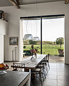Limestone kitchen island in open plan kitchen-diner with vast window