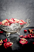 Dried rose petals in a silver sauce boat