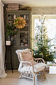 Rattan chair with fur in front of glass cabinet and Christmas tree