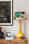 Table lamp with yellow base on a dresser