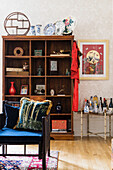 Bookcase, next to it a vintage bar table, in the foreground a chair with a blue cushion